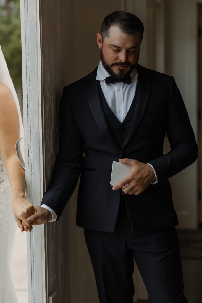 Bride and groom sharing a quiet first touch moment before their wedding ceremony