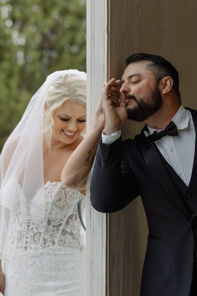 Groom kissing brides hand during a first touch before their Colorado wedding ceremony