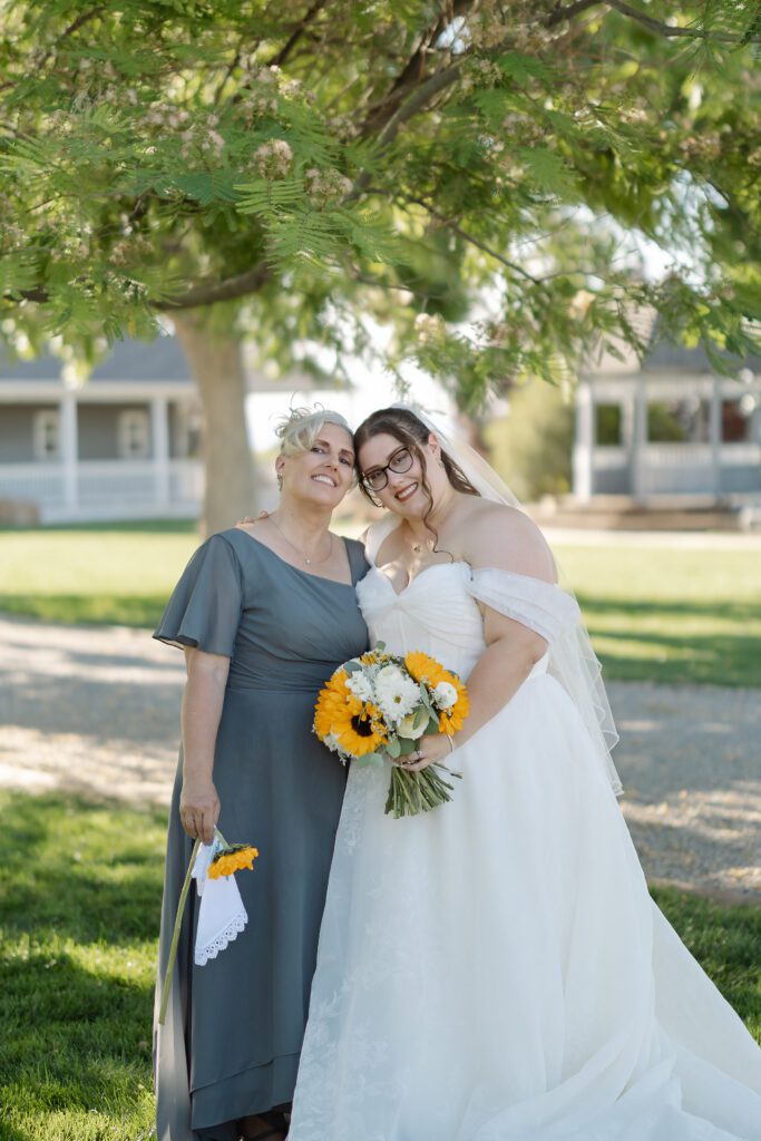 Bride smiling with her mom for portraits after Colorado wedding ceremony