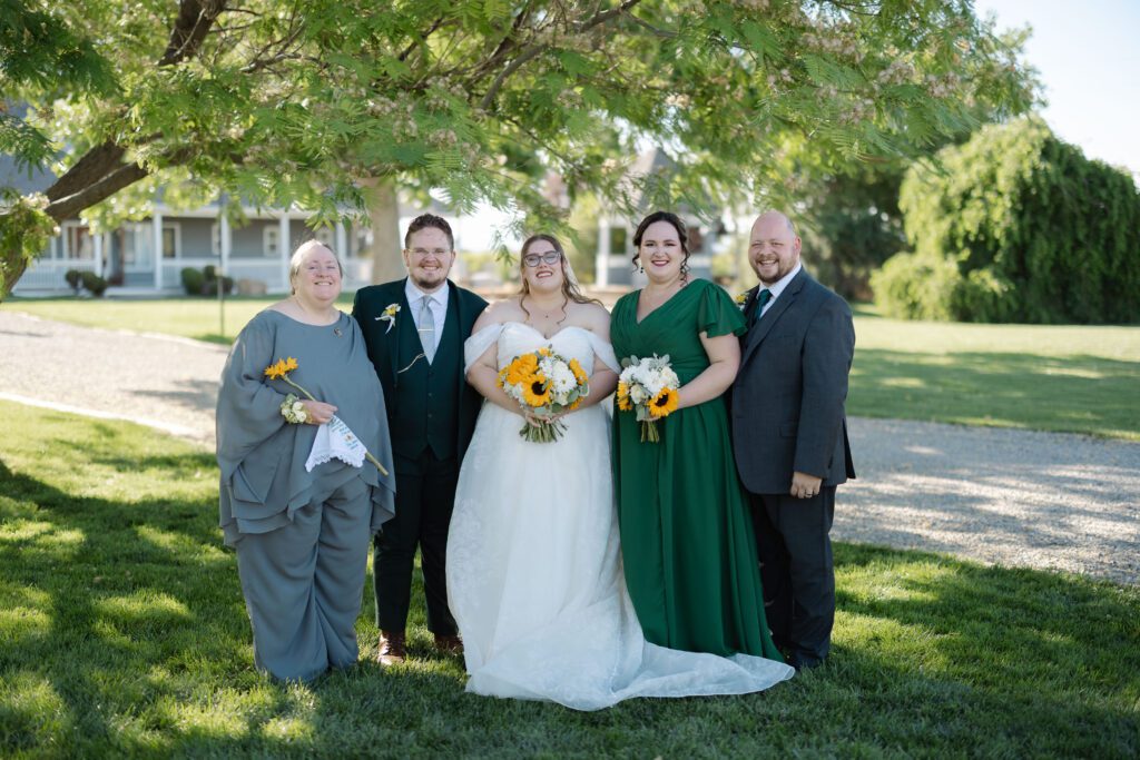 Bride and groom smiling with family during portraits after their Colorado wedding ceremony