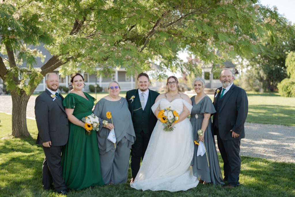 Newlyweds posing with family members for formal. portraits at their Colorado wedding