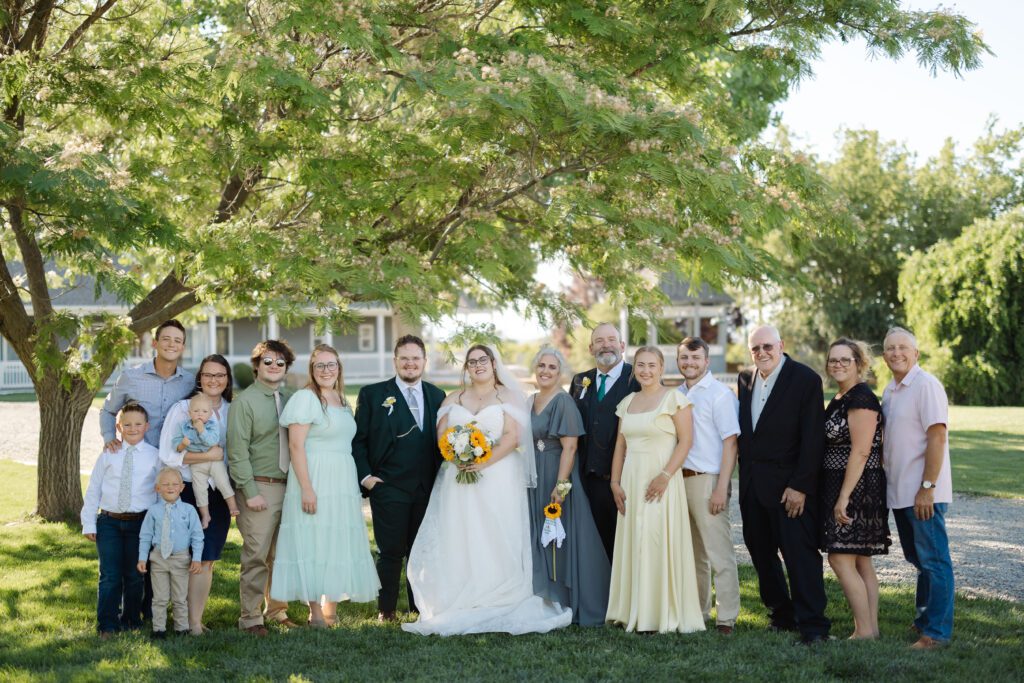 Bride and groom posing with family members after their Colorado wedding ceremony